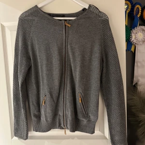 Helt ny grå kofta  - Helt ny grå kofta med guldiga detaljer