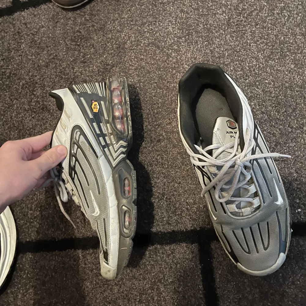 Säljer ett par Nike Air Max sneakers i grått med svarta detaljer. Skorna har en unik design med synlig Air Max-dämpning i sulan och snörning framtill. Perfekta för en sportig look. 45 men passar mer storlek 44.. Kengät.