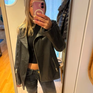 Svart skinnjacka - Snygg svart skinnjacka med dragkedja och flera fickor. 