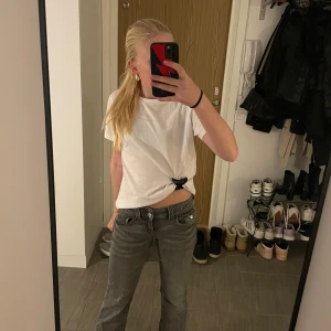 Grå bootcut jeans från Gina Tricot - Snygga grå bootcut jeans från Gina Tricot. De har en klassisk femficksdesign och stängs med knapp och dragkedja. Perfekta för en avslappnad stil med en touch av retro. De är i superbra skick och ser nästan helt nya ut. Utsvängda till botten och lite tajtare upptill med två knappar att stänga byxan med. Perfekt för en dag med lite sol med en t-shirt och en hoodie!☺️
