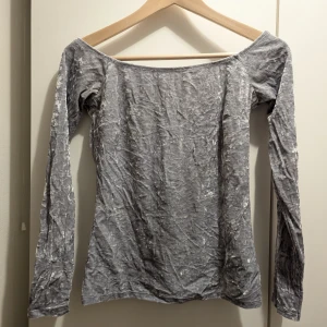 Grå långärmad topp - Säljer en fin grå långärmad topp med en glansig yta.😊 Säljer då den är för liten för mig.