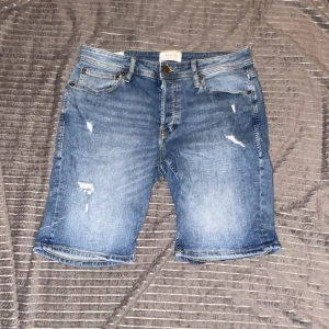 Blå jeansshorts - Snygga blå jeansshorts från Jack and Jones med slitna detaljer 