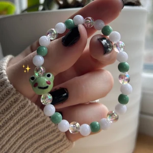 grodarmband 🐸 - 35/kr styck, Pärlarmband med en handgjort pärla i form som en groda 🐸💚 supersöt accessoar till den som tycker om söta saker! Tillverkade med dubbla trådar för säkerhet! (Frakt frimärke 18 kr eller via plick)
