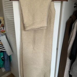 Beige stickade byxor från Zara - Säljer ett par mysiga beige stickade byxor från Zara. De har en enkel design med elastisk midja för extra komfort. Lite smutsiga i kanten men det går nog att tvätta bort!