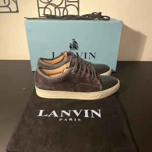 Svarta lanvins  - Snygga svarta sneakers från Lanvin captoe i mocka med snörning och en vit sula. Skorna är UK 6 vilket motsvarar 41/42. Skorna är i väldigt fint skick. allt og |Extra snöre|dustbag|box| skorna är använda 10 gånger. Nypris ligger på 5500kr😁 Priset går att diskuteras, bara att höra av er.