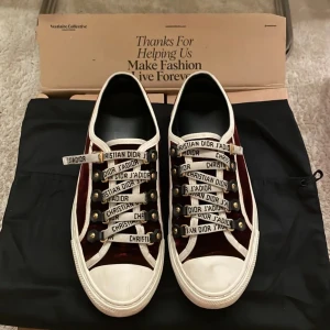 Vinröda sneakers från Christian Dior - Snygga vinröda sneakers från Christian Dior med vita detaljer och text på snörningen. Modellen är Walk’n! Super fint skick och super fina men har tyvärr växt ur de! Kvitto osv & Kan mötas upp i Stockholm eller posta spårbart🫶🏻