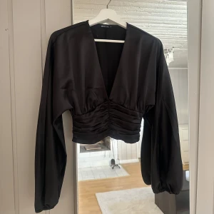 Ginatricot satintopp  - Säljer denna fina svarta satintoppen från ginatricot, helt oanvänd.