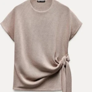 Beige topp från Zara - Säljer en beige topp från Zara med korta ärmar och en snygg knytdetalj på sidan pågrund av att den inte kommer till användning längre