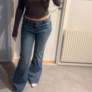 Blå bootcut jeans - Snygga blå bootcut jeans med hög midja. Perfekta för en avslappnad stil med en modern touch. De har en klassisk femficksdesign och en bekväm passform.