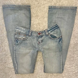 Ljusblå bootcut jeans med låg midja - Lågmidjade utsvängda jeans från märket Cropp! Midjemåttet är 38 cm rakt över och innerbenslöngden är 84 cm. Favorit jeans som tyvärr har slitage på bältesgrejerna i båda sidorn men inget märkbart💖💖köpta av lilou uf för några månader sedan😇
