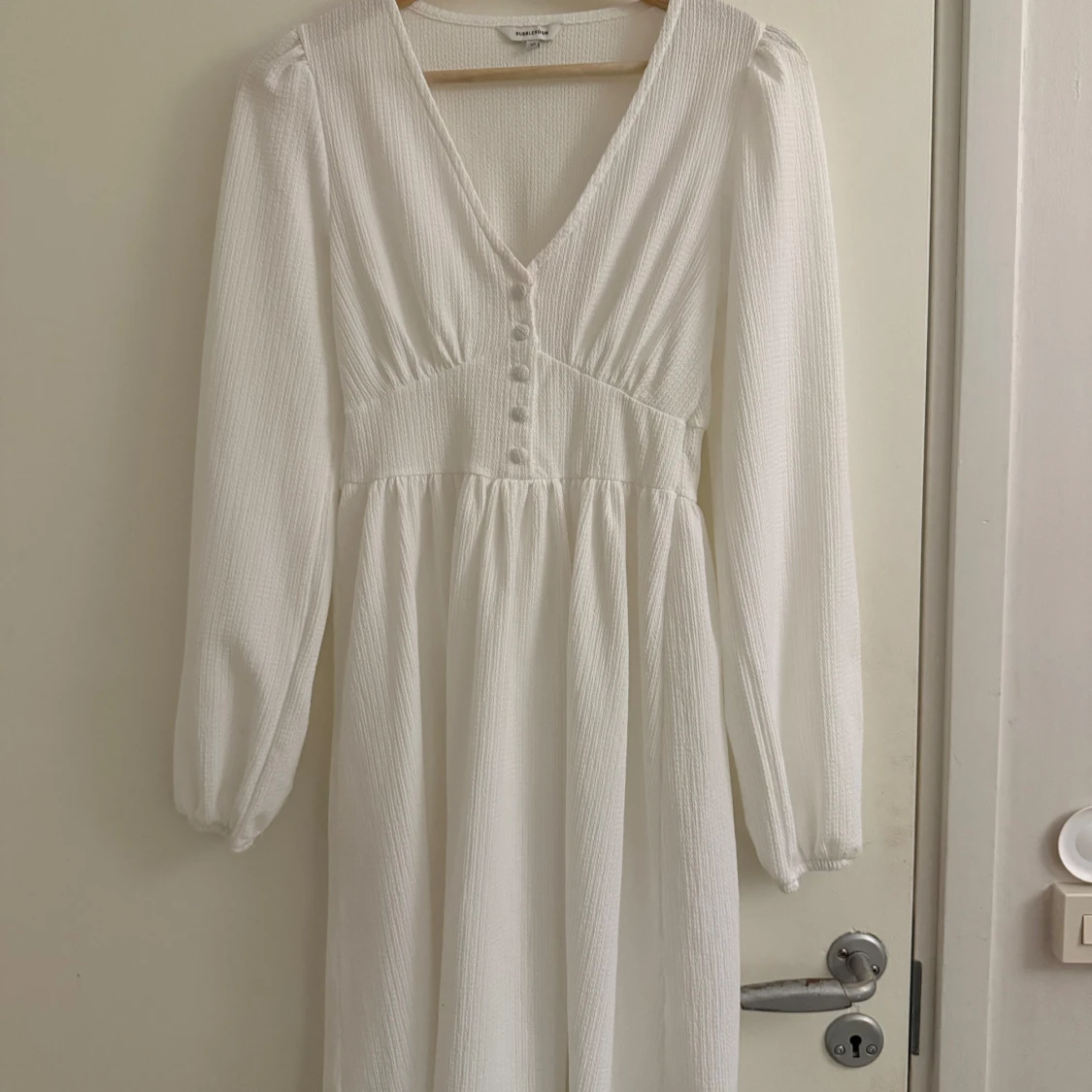 Vit långärmad klänning med knappar