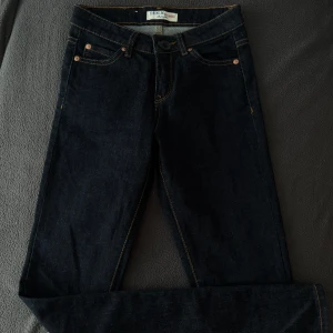 Mörkblå jeansbyxor från Denim Alliance - Snygga mörkblå jeansbyxor från Denim Alliance med klassisk femficksdesign och kontrastsömmar. Byxorna har rak passform och är tillverkade i slitstarkt jeanstyg. Perfekta för en stilren och enkel look.