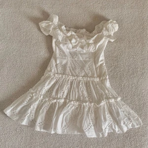 Vit offshoulder klänning med volang - Superfin vit kortklänning från Zara. Kommer inte till användning. Perfekt för sommar o fest!! 