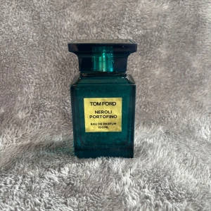Tom Ford Neroli Portofino 100ml - Tom Ford Neroli Portofino Eau de Parfum i en lyxig, turkosblå glasflaska med guldig etikett. Flaskan rymmer 100 ml och kommer i en matchande turkos kartong med gulddetaljer. En ikonisk doft med fräsch citrus och blommiga toner.