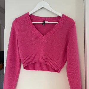 Rosa croppad stickad tröja H&M Divided - Superfin rosa croppad stickad tröja från H&M Divided. Tröjan har v-ringning, ribbade muddar och lång ärm. Använd 1 gång, väldigt mjukt material.
