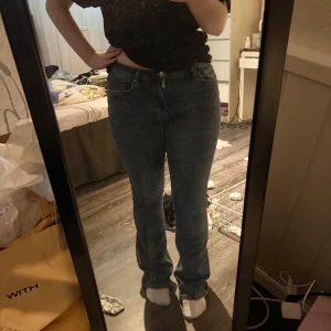 Blå bootcut jeans med låg midja - Säljer ett par klassiska blå jeans med bootcut-modell och låg midja. Jeansen har fem fickor, dragkedja och knapp framtill. Har använt en del men inget som syns. 