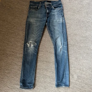 Tiger of sweden jeans - Säljer ett par blå jeans med snygga slitningar och hål på ena benet från tiger of sweden. Storlek 29-32