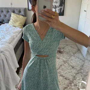 Blommig klänning Pull&Bear - Supersöt blommig klänning ifrån Pull&Bear i mint grönt. Klänningen har v-ringning, korta ärmar, cut-out vid midjan och volangkant nertill.🩵 Perfekt nu inför sommarens alla tillfällen!❣️Klänningen är endast använd en gång, så super fint skick. Skulle även säga att den passar många åldrar, endast använd en gång för två år sedan och den passar fortfarande super fint!🌞 Kontakta vid eventuella frågor❤️