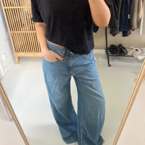 Blåa wide jeans med låg midja - Säljer ett par ljusblå jeans med riktigt breda ben och låg midja. Jeansen har klassisk femficksdesign och stängs med dragkedja och knapp. Perfekta för dig som gillar en avslappnad och trendig look. Använda ett fåtal gånger!❤️