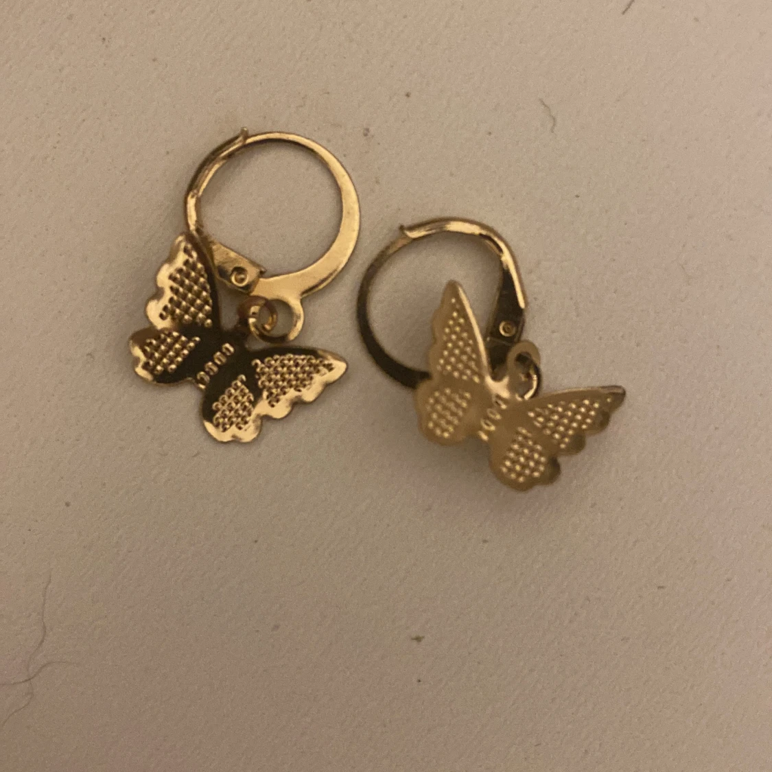 Guldiga örhängen med fjärilar