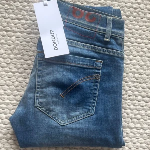 Dondup george - Snygga skinny fit jeans från Dondup i klassisk blå denim i väldigt bra skick. Modellen heter George och har en smal passform som sitter tajt längs benen. Nypris 3399.