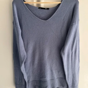 Ljusblå stickad tröja från lager157 - Mysig ljusblå stickad tröja från 157 med v-ringad hals och ribbade muddar nedtill. Perfekt för lager-på-lager och chill dagar. Långärmad och i en skön, lite loose passform som funkar till allt. Använd men i mycket bra skick