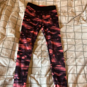 Tränings leggings  - Snygga leggings från H&M Sport med svart och rosa abstrakt mönster. Hög midja med bred resår ( jag vek ner kanterna på bild 2 så dom blir mer low waist), stretchigt material som sitter tight och bekvämt. Perfekta för träning eller chill. Färgerna är riktigt poppiga och ger en cool vibe. Är egentligen i stl 134/140 men passar mig som vanligtvis har 152 elr 158 i byxor så skulle säga att dom passar i 146/152 också. Skriv gärna för fler bilder eller frågor!!💕