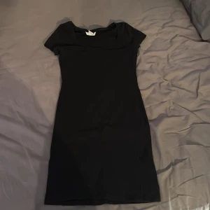 Svart kortärmad klänning - En stilren svart kortklänning med rundad urringning och korta ärmar. 