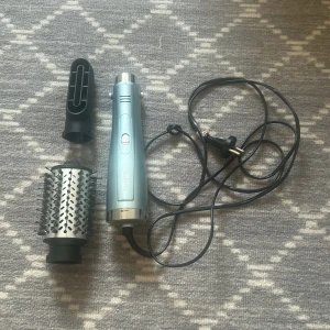 BaByliss blå varmluftsborste - Säljer en blå varmluftsborste från BaByliss med rund metallborste och svart fönmunstycke. Perfekt för att styla och ge volym till håret. Handtaget är ergonomiskt och borsten har svarta piggar för enkel styling. Kommer med två utbytbara tillbehör.