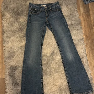 Blå bootcut jeans från Gina Tricot - Snygga blå jeans från Gina Tricot i modell bootcut. Klassisk femficksdesign med kontrastsömmar och dragkedja. Jeansen har en lätt utsvängd passform nertill och är tillverkade i slitstarkt denimtyg.