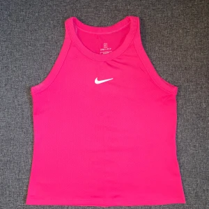 Nike träningslinne - Mörkrosa träningslinne ifrån Nike. Älskar denna färgen och linnet är i jättebra skick. Använd 2ggr💕Säljer en likadan i blå!💙 Köp båda för 150kr 🙌🏼