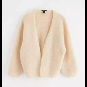 kofta - Supermjuk och oversized beige kofta med djup v-ringning och lång ärm. Perfekt för lager-på-lager och chill dagar. Den fluffiga känslan gör den extra mysig och lätt att matcha med allt.