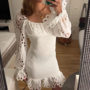 Student klänning - Säljer en superfin vit klänning med långa ärmar och spetsdetaljer. Klänningen har en tight passform och volangdetaljer vid ärmslut och nederkant. Helt ny och endast testat en gång med prislappen kvar💕