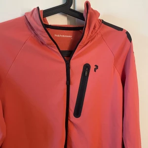 Träningströja  - Aprikosfärgad träningströja. Storlek M från peak performance. Knappt använd så i mycket gott skick. 