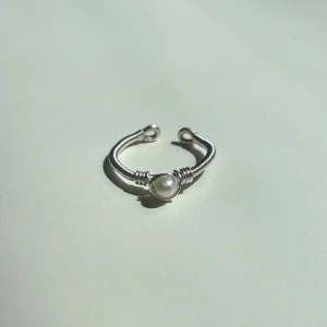 Cleo Ring - Denna ring är tillverkad för hand med rostfri ståltråd som gör den både hållbar och rostfri. Den är justerbar för en perfekt passform och pryds med äkta sötvattenspärla.