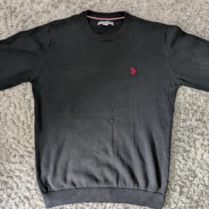Svart tröja från U.S. Polo Assn. - Klassisk svart tröja från U.S. Polo Assn. Med rund halsringning och röd logga broderad på bröstet. Tröjan är i medium men passar Large också!            