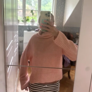 Ljusrosa stickad polotröja - Supermysig ljusrosa stickad polotröja med oversized passform och långa ärmar. Tröjan har breda ribbade muddar och en polokrage.