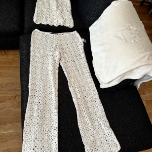 Vita virkade byxor och linne  - Superfina virkade byxor från Bik Bok i vit färg. Byxorna har ett unikt blommigt mönster, raka ben och dragkedja i sidan. Perfekta för sommarens alla tillfällen och ger en riktigt boho-vibe.  ALDRIG ANVÄNT 