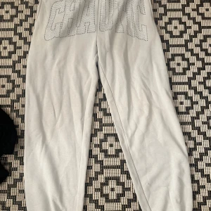 Ljusblå mjukisbyxor  CHAOTIC - Ljusblå mjukisbyxor från PB Sister i storlek S. Byxorna har stora glittriga bokstäver 'CHAOTIC' framtill i strass och dragsko i midjan. Perfekta för chill dagar och har en loose fit med mjukt fleecetyg på insidan.