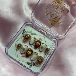 Heartline (S);Short Almond - Snygga gelé press on-naglar i kort mandelform med vinröd, vit och nude brun bas. Naglarna har detaljer i guld som hjärtan, stjärnor och pärlor. Perfekt för dig som vill ha en unik och lyxig look utan att gå till salong. Kommer i storlek S: 15 mm, 11,5 mm, 12 mm, 11 mm, 9 mm 