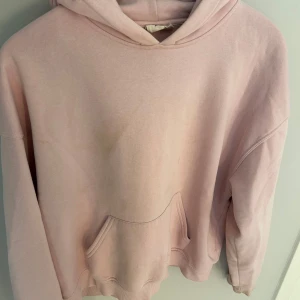 Ljusrosa hoodie från Gina tricot, stl M - Mysig ljusrosa hoodie från Gina tricot med klassisk känguruficka och huva. Tröjan är i mjuk bomullsblandning med fleece på insidan, perfekt för chill dagar. Enkel och stilren design som funkar till det mesta.