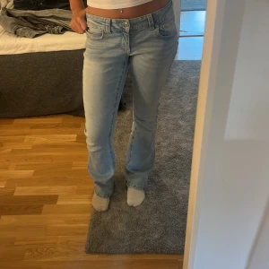 Ljusblå bootcut jeans  - Säljer ett par ljusblå jeans från Pepe Jeans med bootcut passform. Jeansen har klassiska fem fickor, snygga detaljer på bakfickorna och låg midja. Perfekta för dig som gillar en avslappnad men ändå trendig look. Jag har sytt in dem lite grann i midjan men dem var endån förstora för mig och jag e 174. 