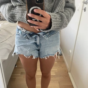Ljusblå jeansshorts från Gina Tricot - Säljer ett par ljusblå jeansshorts från Gina Tricot med fransiga kanter. Shortsen har normal passform och är perfekta för sommardagar. 