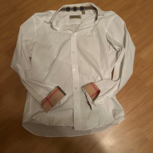 Vit Burberry skjorta med rutiga detaljer - Tja säljer denna riktigt feta burrberry skjorta till riktigt bra pris den är helt ny inga tecken på användning storlek M pris kan diskuteras vid snabb affär hör av er om ni är intresserade 