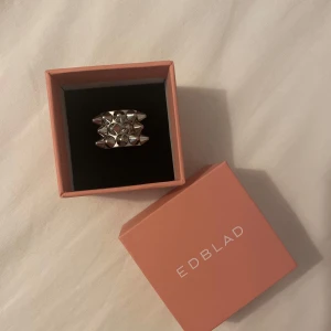 Silver spik ring från Edblad 16:00 - Jag säljer en silver edbladsring i storlek 16:00/ minsta storleken .Köptes förra sommaren och har andvänds mycket så några små repor är på den men märks inte riktigt. Har inga tidliga defekter dock har jag råkat fila på en av spikarna vilket syns i 5e bilden. Låda ingår. Nypris 400 💗