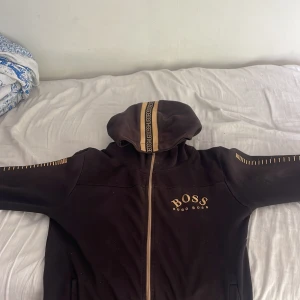 Svart hoodiejacka från Hugo Boss - Svart hoodiejacka från Hugo Boss. Lite solbränd men fin ändå. Vid snabb affär kan priset diskuteras 