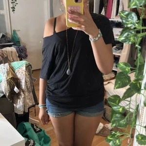 svart t-shirt med öppen rygg - säljer denna t-shirt jag själv klippt av kragen på och klipt strimlorna i ryggen. vet inte exakt storlek men antar M-L