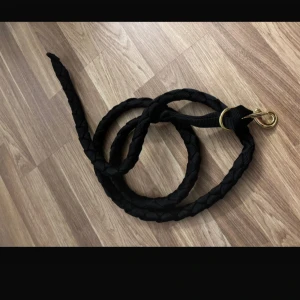 Grimskaft  - Svart grimskaft med guld spännen. 