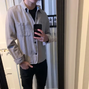 Beige overshirt från dressman  - Säljer en fett overshirt från dressman i st S. Overshirten är i ny skick och kommer till ett väldigt bra pris så passa på innan nån annan😄🤝