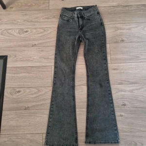 Bootcut jeans från Gina Tricot - Snygga grå/svarta bootcut jeans från Gina Tricot, modell Perfect Jeans. Jeansen har en klassisk femficksdesign, lite högre midja och är tillverkade i stretchig denim. 